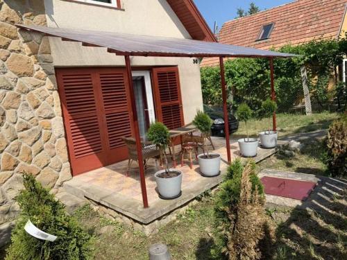 a patio with a table and chairs and an umbrella at Violet Holiday’s House in Siófok