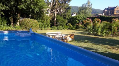 niebieski basen w ogrodzie ze stołem w obiekcie Huize Carmélites w mieście Fumay