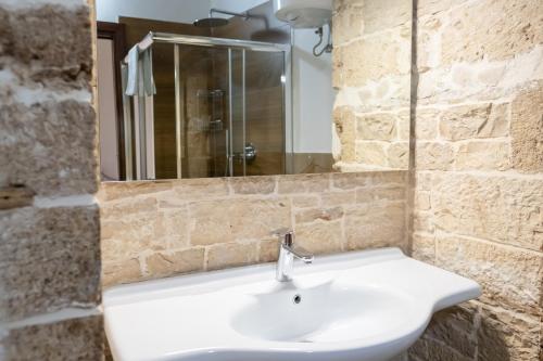 a bathroom with a white sink and a mirror at B&B Santi Medici in Bitonto