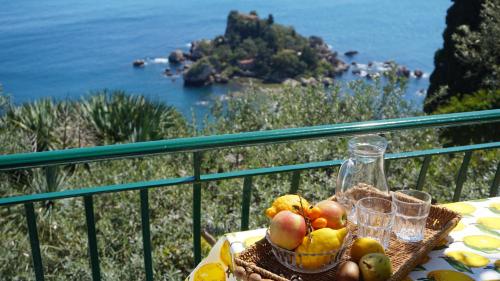 a basket of fruit on a table on a balcony at Residence Terra Rossa Taormina in Taormina