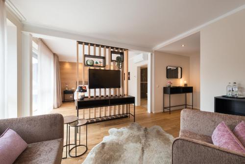 a living room with a couch and a television at MUNTE - Wellnesshotel am Stadtwald in Bremen