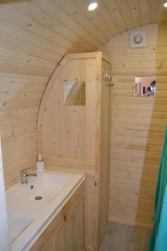 baño con lavabo en una cabaña de madera en LA ROULOTTE VITICOLE, en Cauro