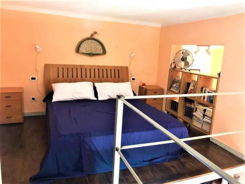 een slaapkamer met een bed met een blauwe deken bij SergioHome in La Spezia