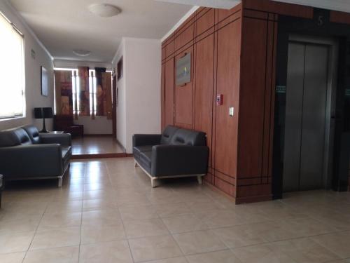 a waiting room with two chairs and a wall at Hotel Campestre Inn in León