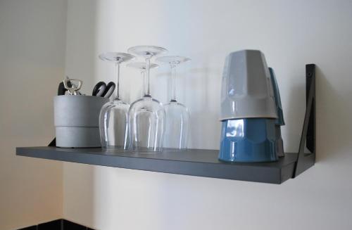 a shelf with wine glasses and a blender on it at Studios am Kniepertor in der Altstadt in Stralsund
