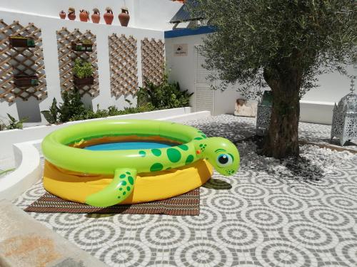 a green and yellow inflatable pool in a yard at Maria`s Guesthouse in Beja