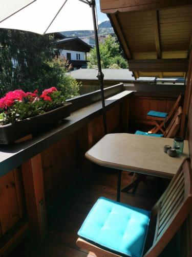 a table and chairs on a balcony with an umbrella at Appartements Told Elisabeth in Fügen