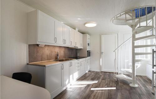 une cuisine avec des placards blancs et un escalier en colimaçon dans l'établissement Beautiful Home In Alingss With Wifi, à Alingsås