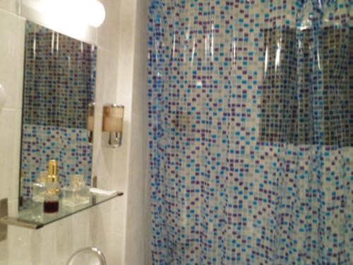 Un baño con ducha con cortina de ducha. en Hôtel De Paris Opera, en París
