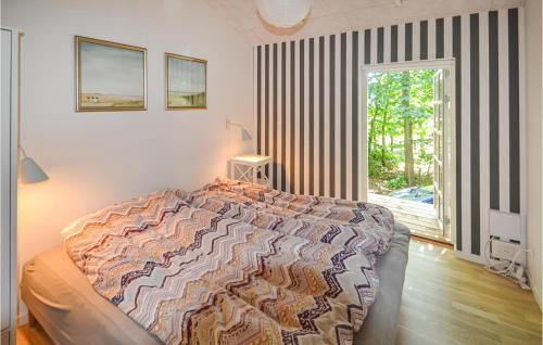 a bedroom with a large bed and a window at 3 Bedroom Awesome Home In Glesborg in Glesborg