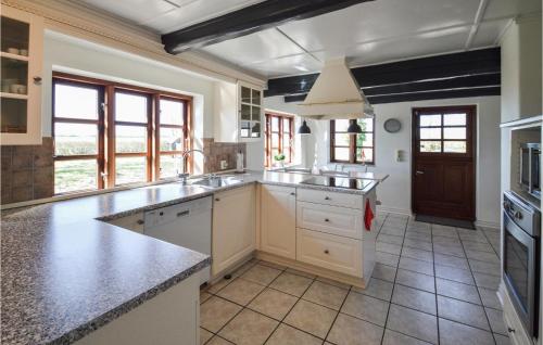 a large kitchen with white cabinets and a sink at Amazing Home In Søllested With Wifi in Søllested