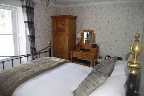 a bedroom with a bed and a dresser and a mirror at Brunswick House in Middleton in Teesdale