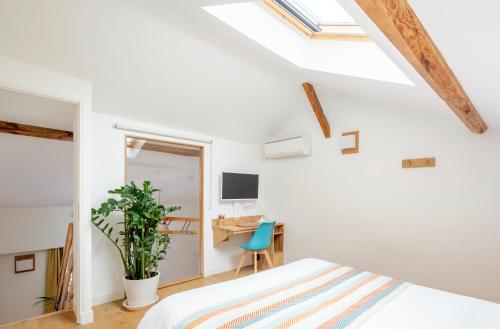 1 dormitorio con paredes blancas, 1 cama y escritorio en Lyon Urban Cocoon Gîte urbain eco-responsable en Lyon