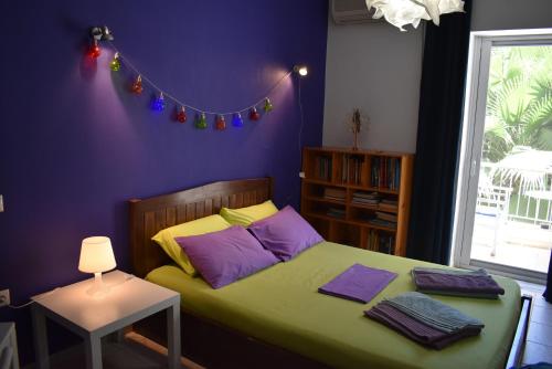 ein Schlafzimmer mit einem grünen Bett mit lila Wänden in der Unterkunft Sophie's choice in Nafplio