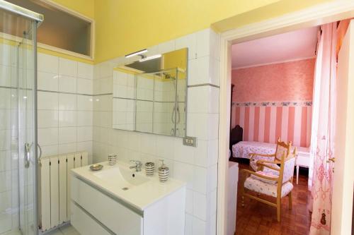 y baño blanco con lavabo y ducha. en B&B Milù, en Civitanova Marche