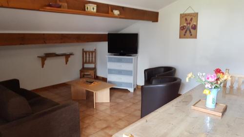 sala de estar con sofá, TV y mesa en Chalet le Feufy, en Morzine