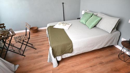 a bedroom with a bed with green and white pillows at L'Iris B&B in Terrazza in Lucca