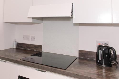 a black tea kettle on a counter in a kitchen at GreenStar Apartments in Dundee