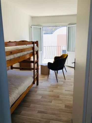 Cette chambre dispose de lits superposés, d'une chaise et d'une fenêtre. dans l'établissement Artimon Beach appart Les Sables d Olonne, à Les Sables-dʼOlonne