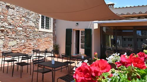 a patio with tables and chairs and red flowers at L'Iris B&B in Terrazza in Lucca