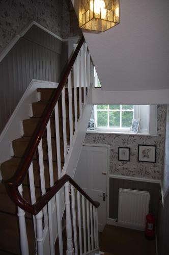 a staircase with a chandelier and a window at Brunswick House in Middleton in Teesdale