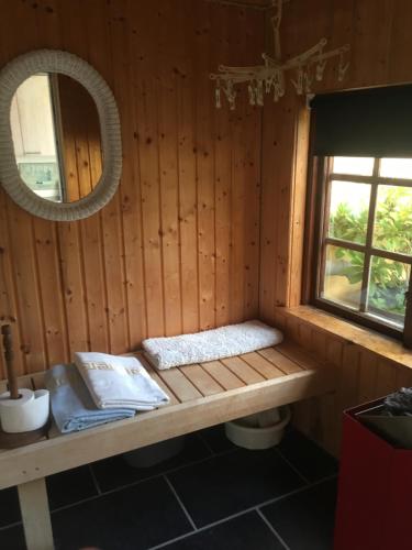 Cabaña de madera con banco en una ventana en anneks til bondehus, en Randers