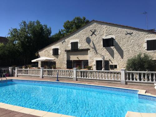 a house with a swimming pool in front of a building at LES GRANGES in Les Lèves-et-Thoumeyragues