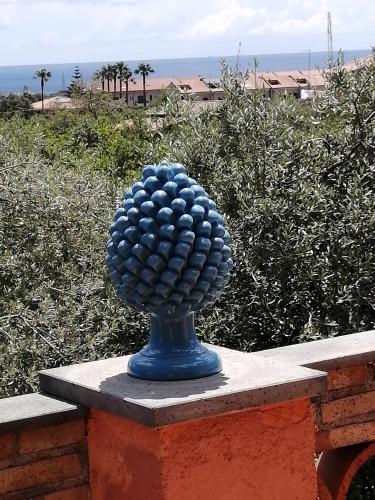 a blue sphere statue sitting on top of a wall at Il Melicucco in Furci Siculo
