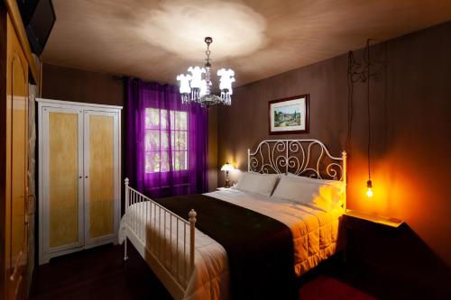 a bedroom with a bed and a chandelier at Agro da Gandarela in Teo
