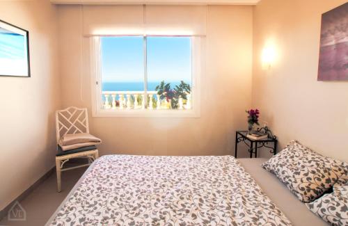 - une chambre avec un lit et une fenêtre offrant une vue sur l'océan dans l'établissement Casa Alena, à Santa Úrsula