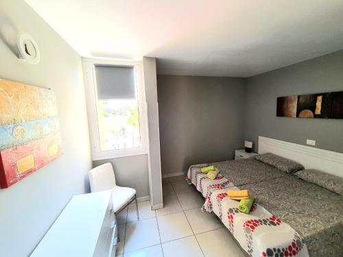 1 dormitorio con 2 camas y ventana en Duplex El Cortijo, LasAmericas, en Playa de las Américas