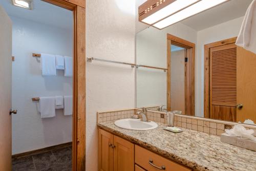 La salle de bains est pourvue d'un lavabo et d'un miroir. dans l'établissement Smokey Plaza Condo 1 - Just Blocks from Bald Mountain & Hot Tub Onsite, à Ketchum