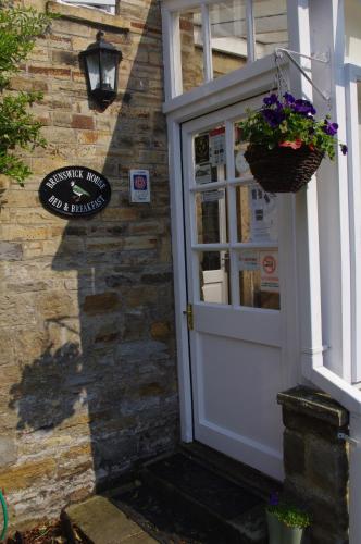 a door to a building with a basket of flowers at Brunswick House in Middleton in Teesdale