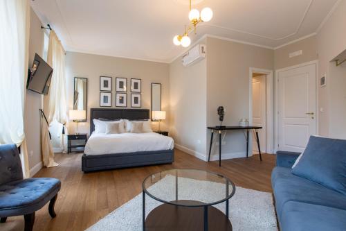 ein Schlafzimmer mit einem Bett, einem Sofa und einem Tisch in der Unterkunft Daplace - Corso Monforte Suites in Mailand