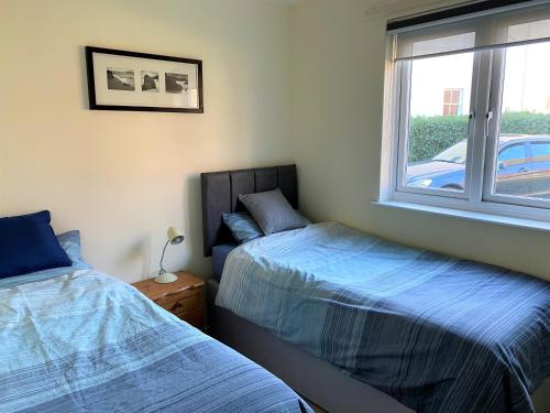 1 dormitorio con 2 camas y ventana en Luxury Suntrap in Private Complex St Leonards, en Hastings