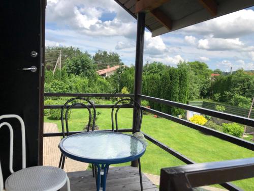 a table and chairs on a balcony with a view at Arvydo Gylio sodyba in Ignalina