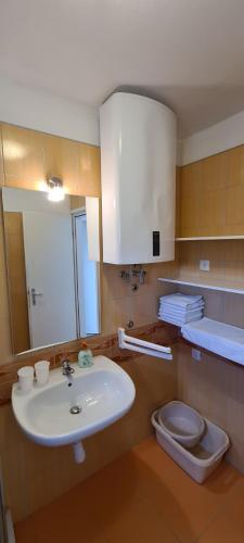 a bathroom with a sink and a toilet at Apartmani Cesar in Rtina