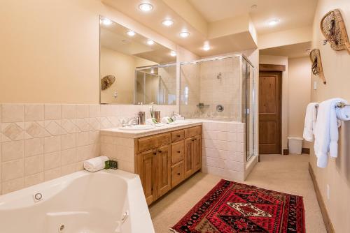 a bathroom with a tub and a sink and a mirror at Westridge Condo 27 - Cozy Condo Walk to Bald Mt and Downtown Ketchum in Ketchum