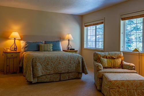 een slaapkamer met een bed, een stoel en ramen bij Yeager Private Home with Room For the Whole Family and Elkhorn Amenities in Elkhorn Village