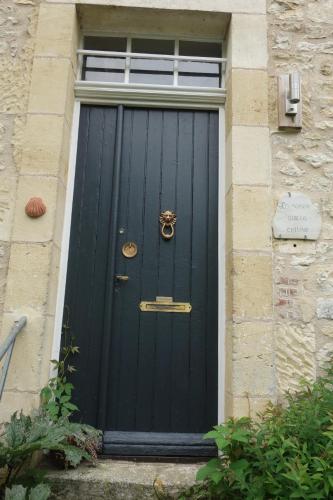 a black door on a building with a window at La Maison sur la Colline in Mauroux