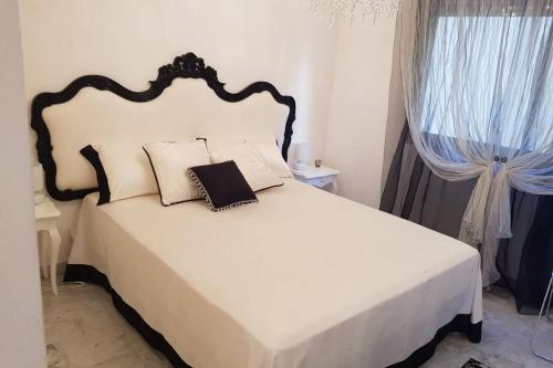 - une chambre avec un lit blanc et une tête de lit noire dans l'établissement Face à la mer, à Menton