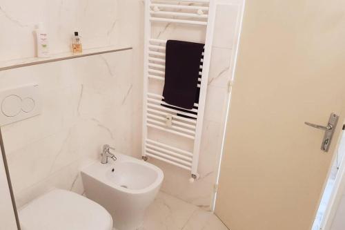 une salle de bain blanche avec des toilettes et un lavabo dans l'établissement Face à la mer, à Menton