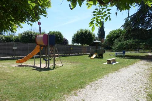 un parco giochi con scivolo in erba di Le gite du Canal a Noyers-sur-Cher