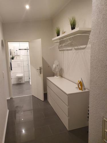 uma casa de banho branca com um lavatório e um WC em Ella's Wolke Appartements - EW2 em Zweibrücken