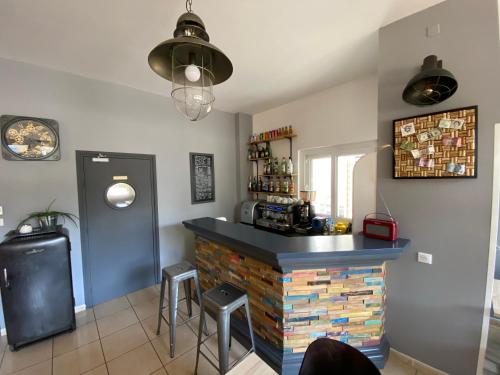 a kitchen with a bar with stools in a room at REV HÔTEL in Lamalou-les-Bains