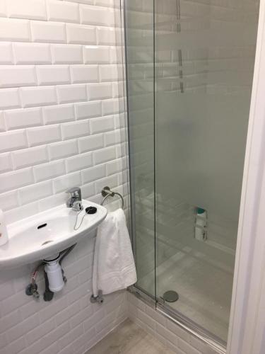 a white bathroom with a sink and a shower at Castro Sun And Beach in Castro-Urdiales