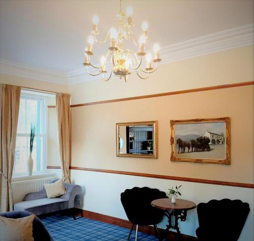 a living room with a chandelier and a table and chairs at Buttermere Court Hotel in Buttermere