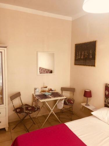 a room with a table and two chairs and a bed at All My Home in Villa San Giovanni