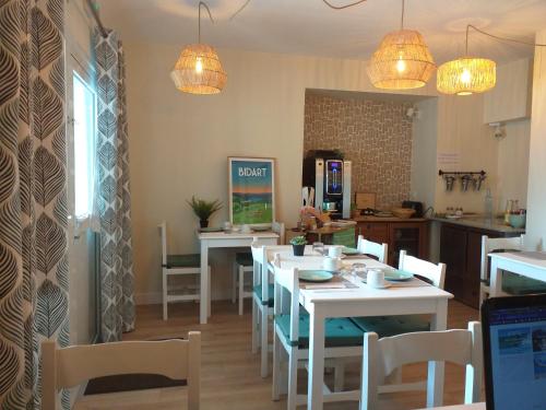 a dining room with tables and chairs and lights at Hôtel & Appart-hôtel Olatua in Bidart