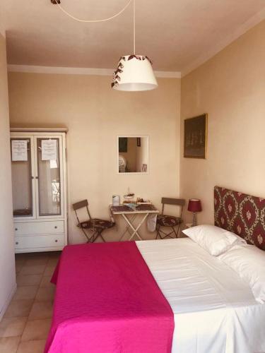 a bedroom with a large bed with a pink blanket at All My Home in Villa San Giovanni